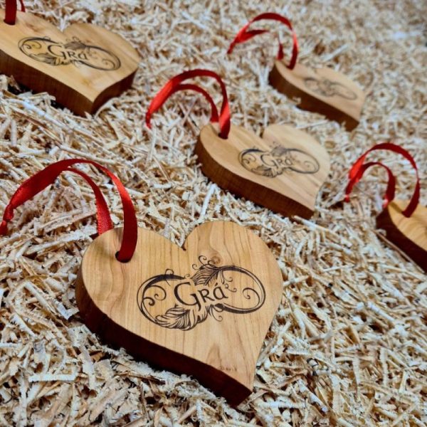 Five wooden love heart decorations engraved with Gaelic word for "Love" - "Grá". With red ribbon attached.